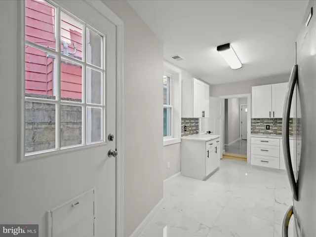 a kitchen with white cabinets and refrigerator