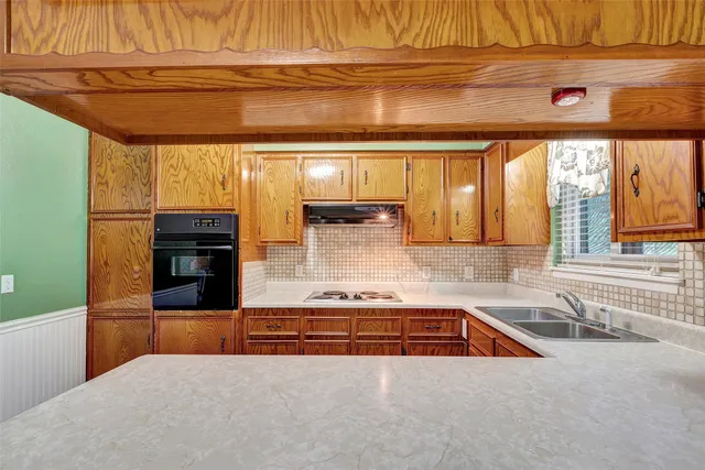 a kitchen with stainless steel appliances kitchen island granite countertop a sink and a stove