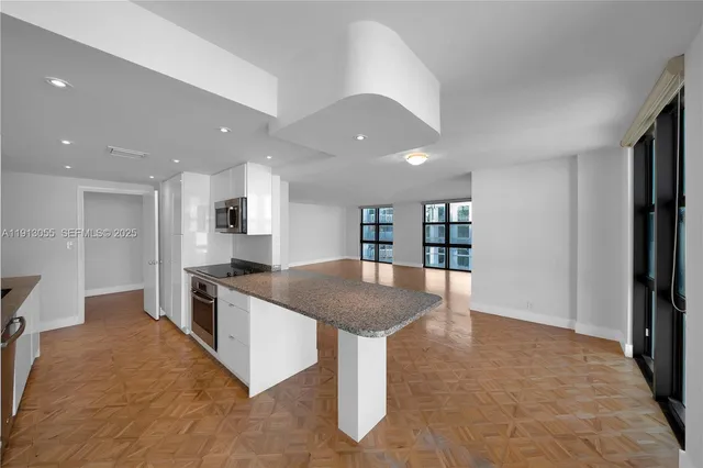 a kitchen with stainless steel appliances granite countertop a refrigerator and a stove top oven