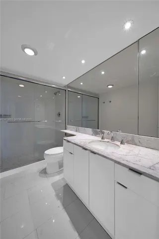 a bathroom with a granite countertop sink a toilet and a mirror