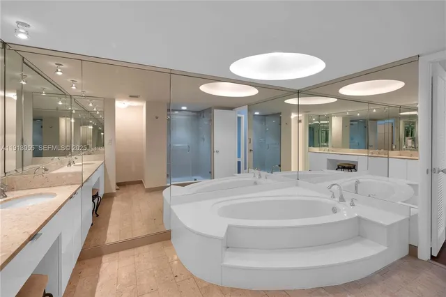 a bathroom with a tub sink and mirror