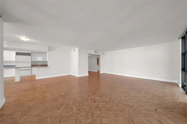 a view of an empty room with a kitchen