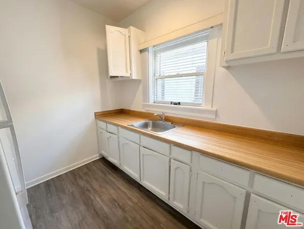 a view of a kitchen with wooden floor and a window