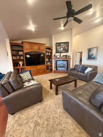 3145 South 500 West Vernal, UT 84078 - Photo 63 of 64 Living room with a ceiling fan, vaulted ceiling, a fireplace, and light carpet