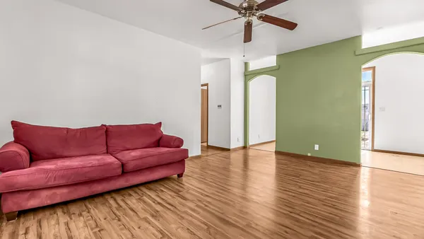 a living room with furniture and a wooden floor