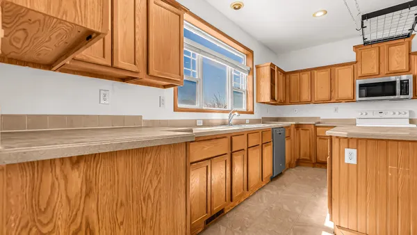 a kitchen with stainless steel appliances wooden cabinets a sink and a microwave