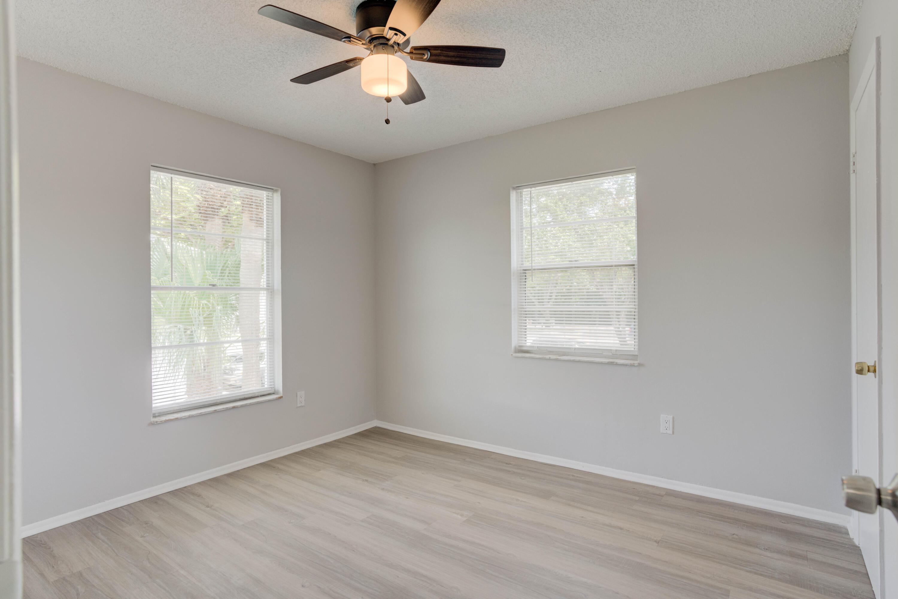6610 Jupiter Gardens Boulevard, Unit F Jupiter, FL 33458 - Photo 9 of 14 a view of an empty room with wooden floor and a window