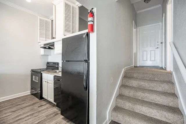 a kitchen with a refrigerator and white cabinets