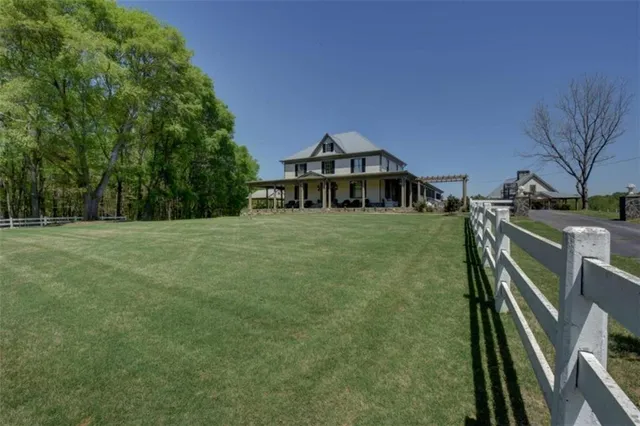a front view of a house with garden and sitting area