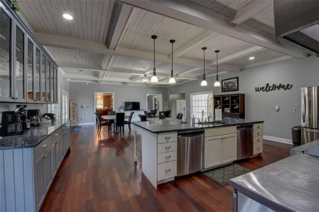 a kitchen with granite countertop a sink stove and cabinets