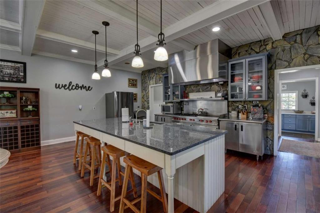7527 Highway 326 Commerce, GA 30530 - Photo 24 of 57 a kitchen with stainless steel appliances granite countertop a sink a stove and a wooden floors