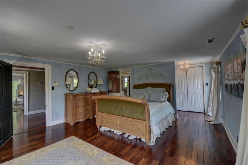 7527 Highway 326 Commerce, GA 30530 - Photo 33 of 57 a bed room with a bed and a chandelier