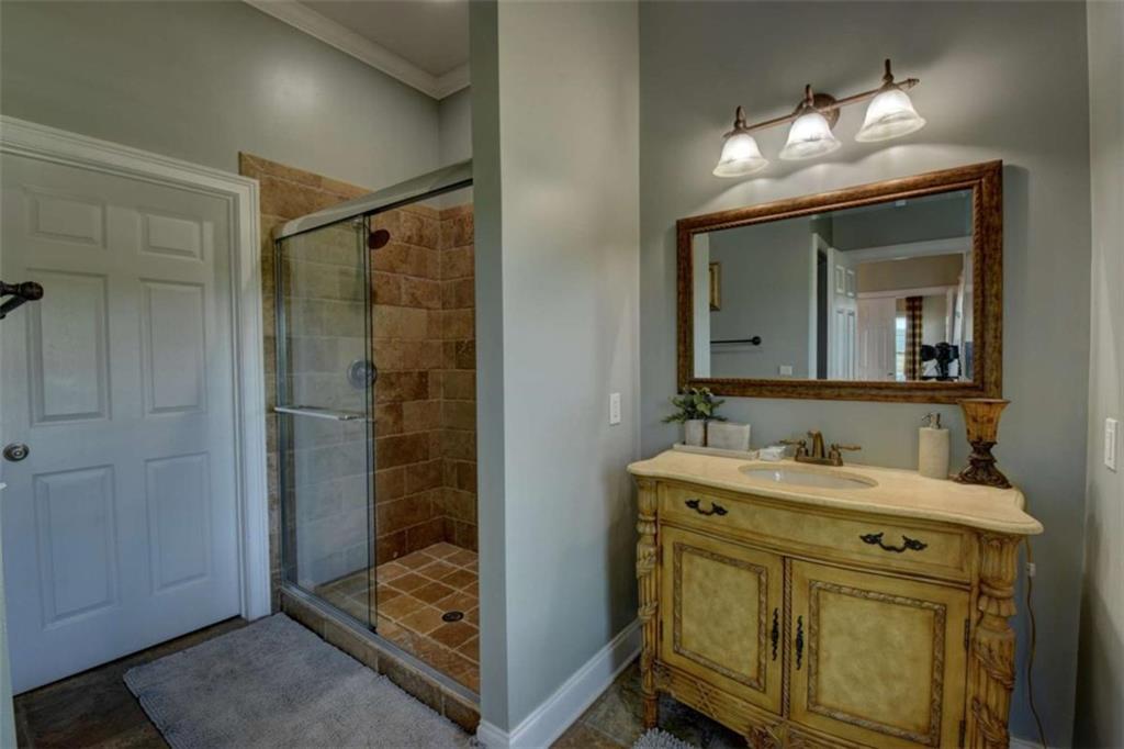 7527 Highway 326 Commerce, GA 30530 - Photo 43 of 57 a en suite bathroom with a granite countertop sink mirror and shower