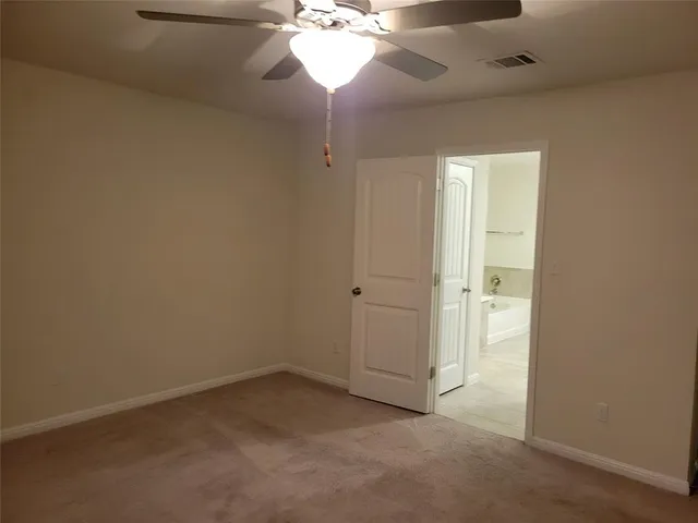 an empty room with a chandelier fan and closet