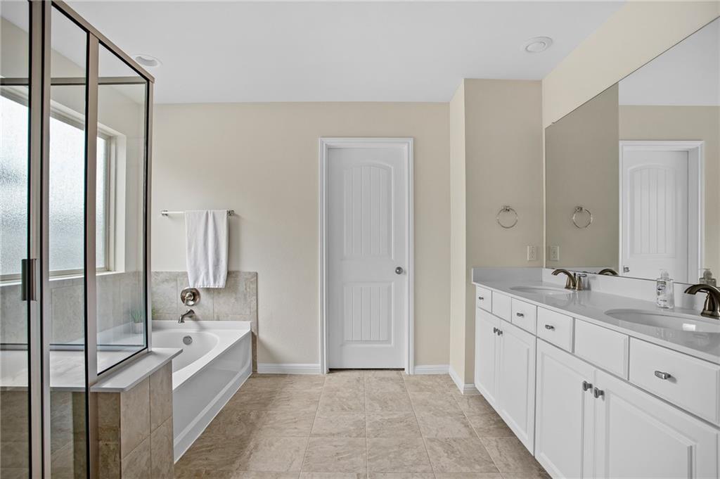 214 Diamond Point Drive Dripping Springs, TX 78620 - Photo 7 of 32 a spacious bathroom with a double vanity sink a mirror and a bathtub