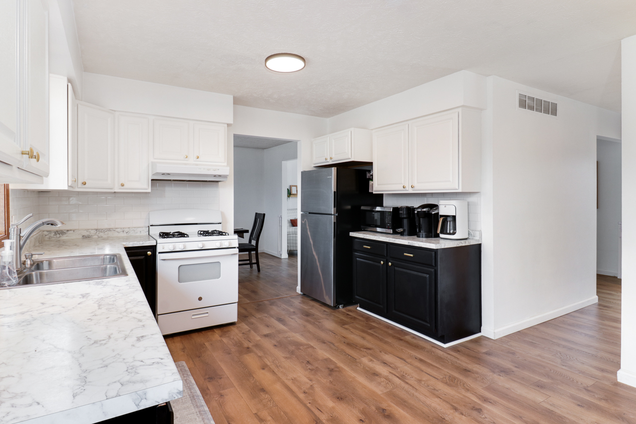 307 Garden Road Normal, IL 61761 - Photo 7 of 32 a kitchen with granite countertop a refrigerator stove a sink and dishwasher with wooden floor