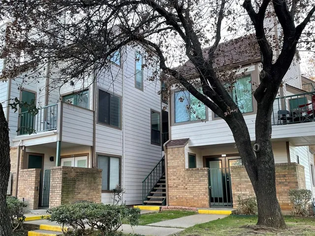 a front view of a house with a tree