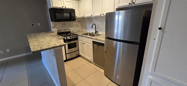 a kitchen with stainless steel appliances a refrigerator a stove a microwave and cabinets