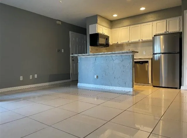 a kitchen with stainless steel appliances a refrigerator and a stove top oven