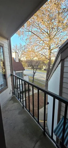 a view of balcony with wooden floor and fence
