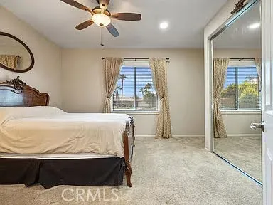 a bedroom with a bed and ceiling fan