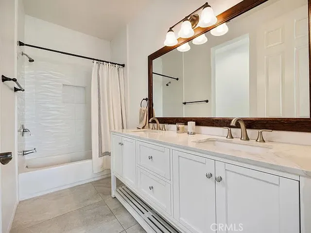 a bathroom with a double vanity sink mirror and shower