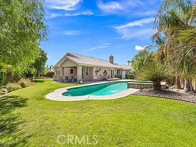 a house view with swimming pool in front of it