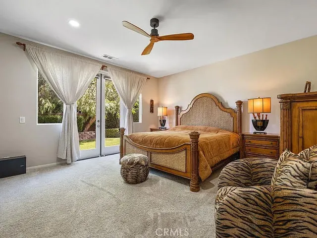 a spacious bedroom with a bed and large window