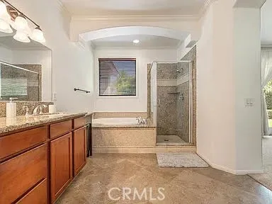 a spacious bathroom with a granite countertop sink mirror and bathtub