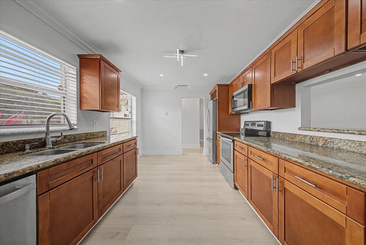 7781 Northwest 46th Street Lauderhill, FL 33351 - Photo 12 of 42 a large kitchen with stainless steel appliances granite countertop a stove sink and cabinets