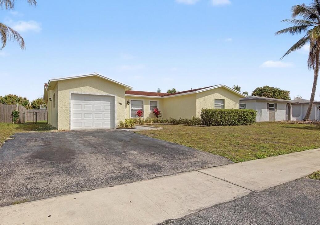 7781 Northwest 46th Street Lauderhill, FL 33351 - Photo 2 of 42 a front view of a house with a yard and garage
