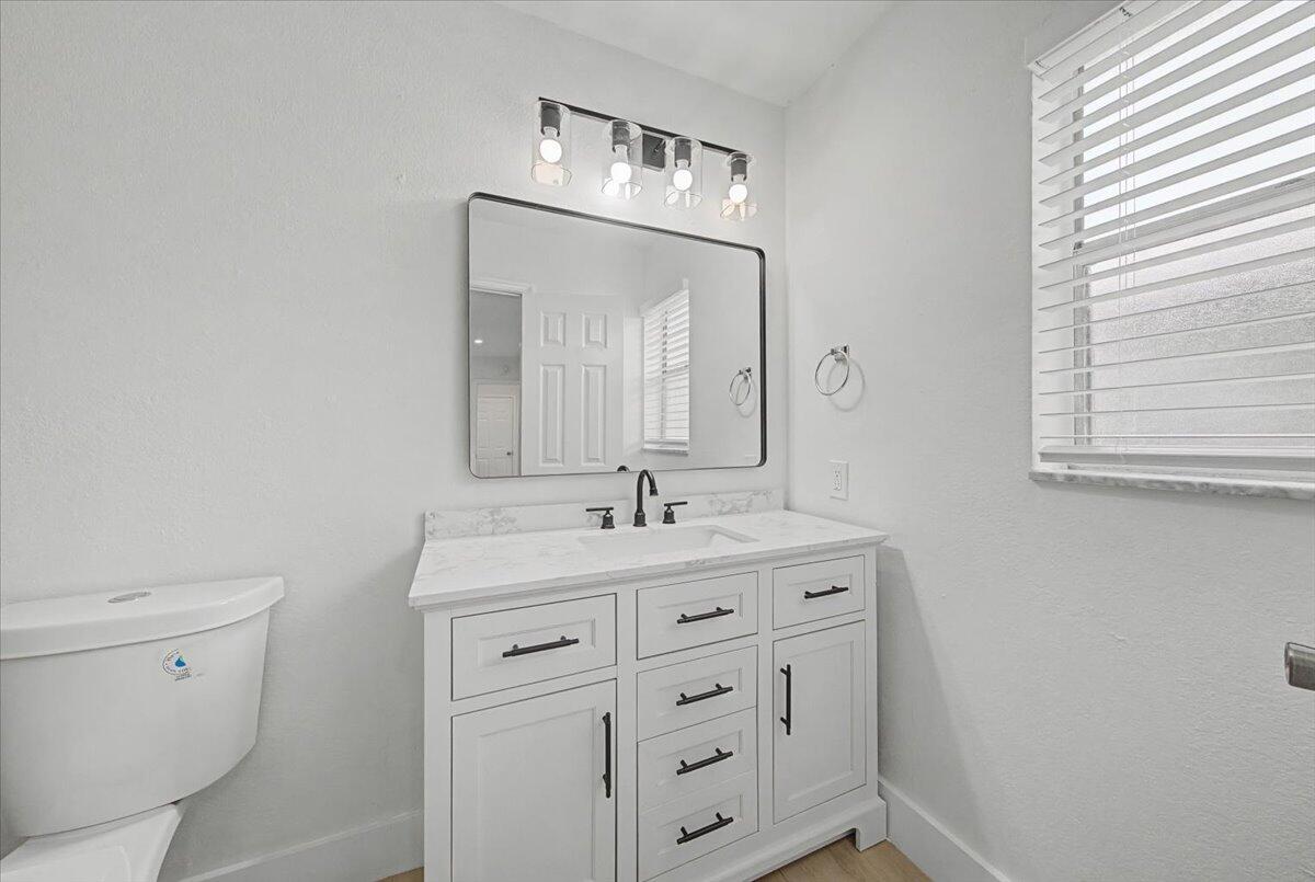 7781 Northwest 46th Street Lauderhill, FL 33351 - Photo 29 of 42 a bathroom with a toilet sink and mirror