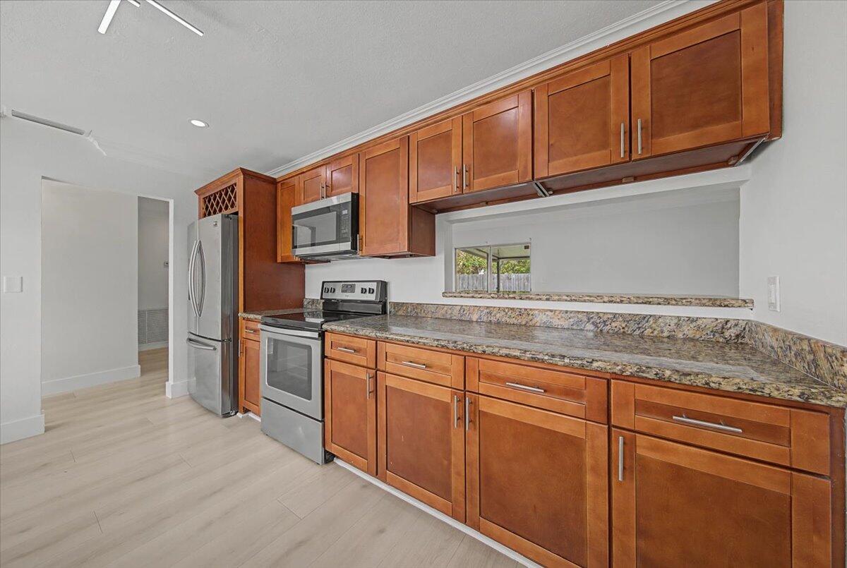 7781 Northwest 46th Street Lauderhill, FL 33351 - Photo 7 of 42 a kitchen with stainless steel appliances granite countertop a refrigerator and cabinets