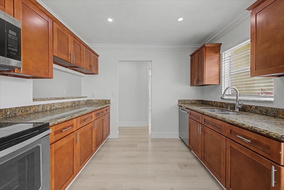 7781 Northwest 46th Street Lauderhill, FL 33351 - Photo 9 of 42 a large kitchen with stainless steel appliances granite countertop a sink and a stove