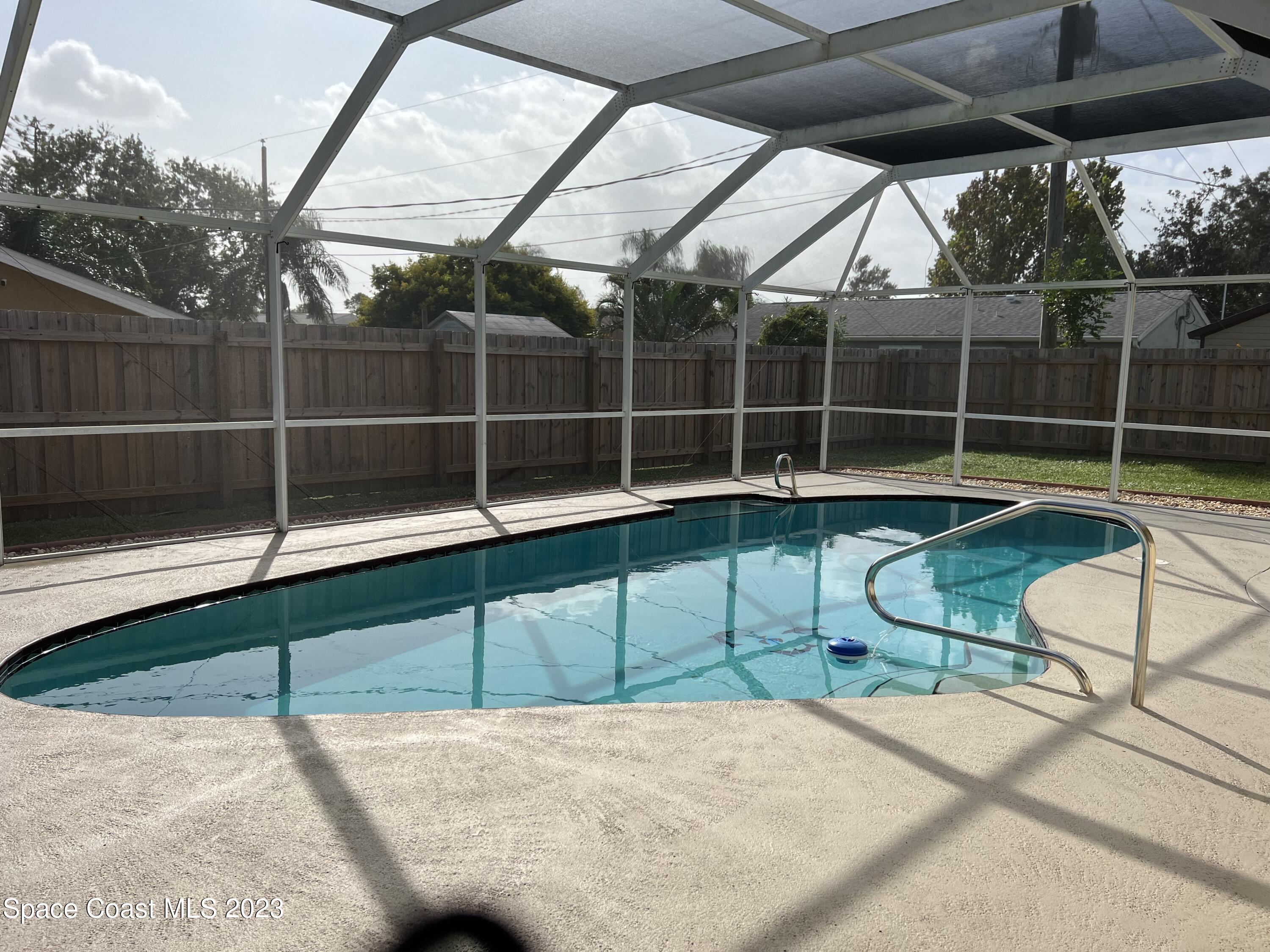 283 Fecco Street Cocoa, FL 32927 - Photo 18 of 25 a view of a swimming pool with a chair and table in the patio