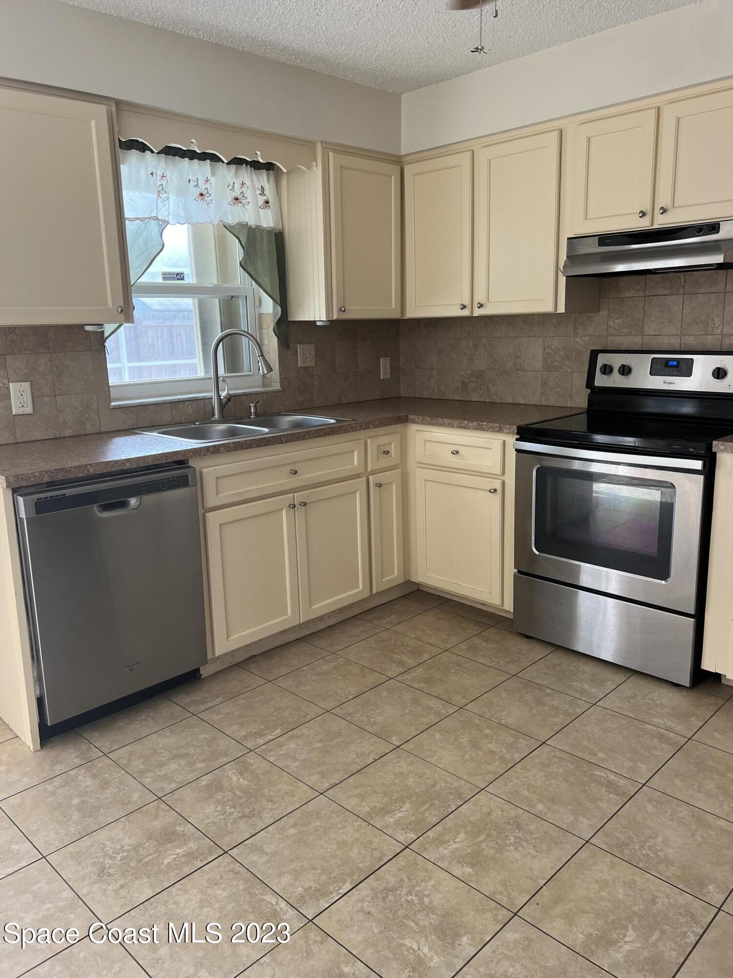 283 Fecco Street Cocoa, FL 32927 - Photo 7 of 25 a kitchen with stainless steel appliances granite countertop a sink stove and cabinets