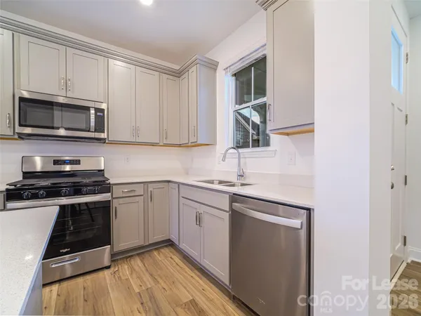 a kitchen with granite countertop a sink and steel appliances
