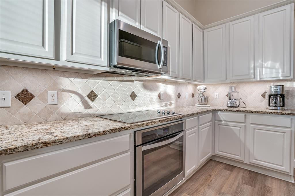 2129 Clubside Drive Corinth, TX 76210 - Photo 14 of 39 a kitchen with granite countertop white cabinets and a stove top oven