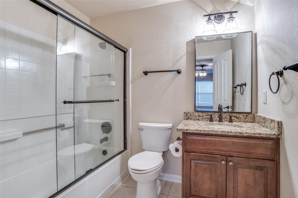 2129 Clubside Drive Corinth, TX 76210 - Photo 23 of 39 a bathroom with a granite countertop sink toilet and shower