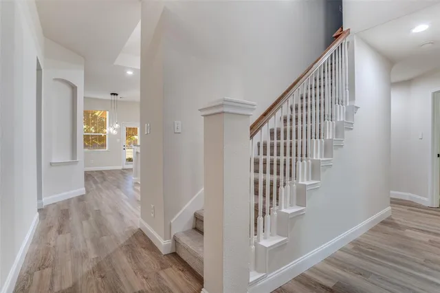 a view of hallway with stairs and wooden floor