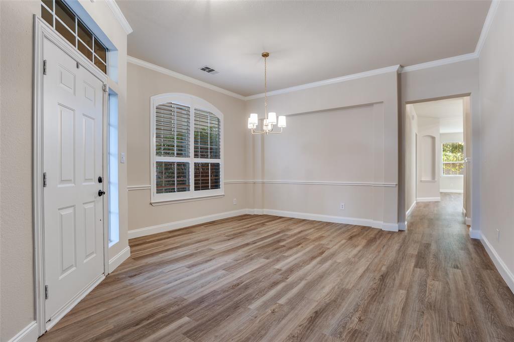 2129 Clubside Drive Corinth, TX 76210 - Photo 9 of 39 a view of an empty room with wooden floor and a window