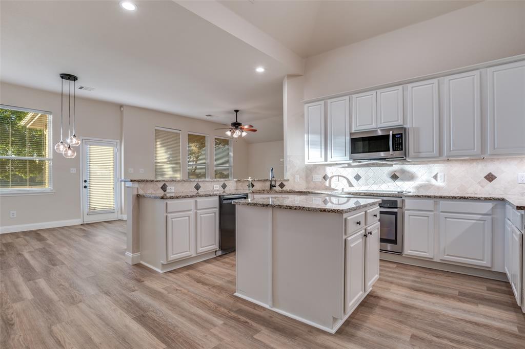 2129 Clubside Drive Corinth, TX 76210 - Photo 10 of 39 a kitchen with kitchen island granite countertop a sink cabinets and wooden floor