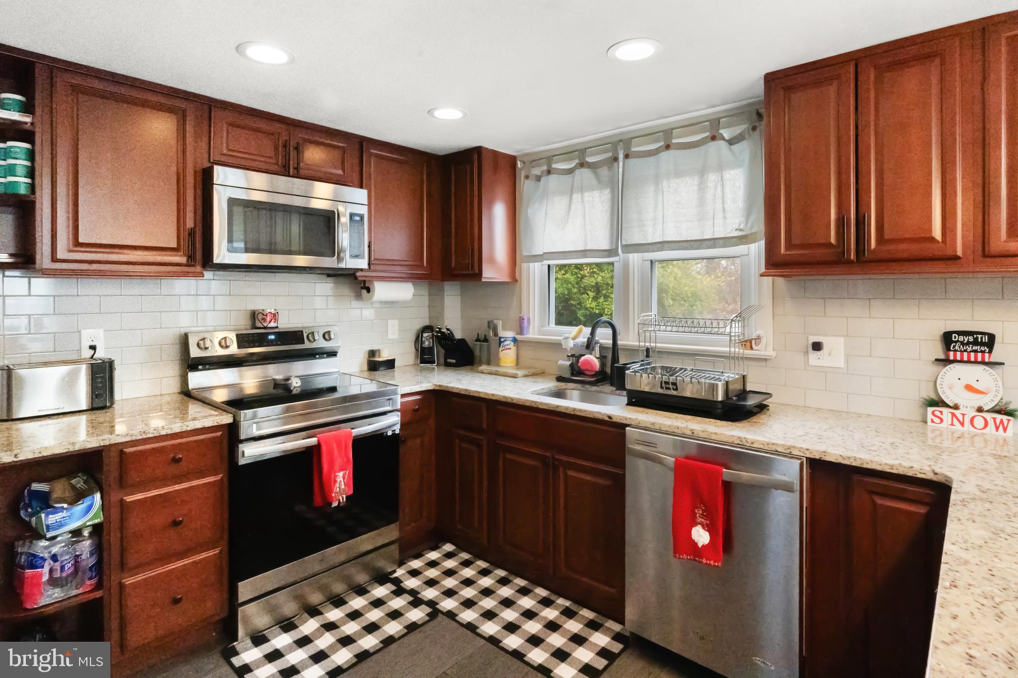 17 Upland Road Brookhaven, PA 19015 - Photo 10 of 25 a kitchen with stainless steel appliances granite countertop a sink stove refrigerator and cabinets