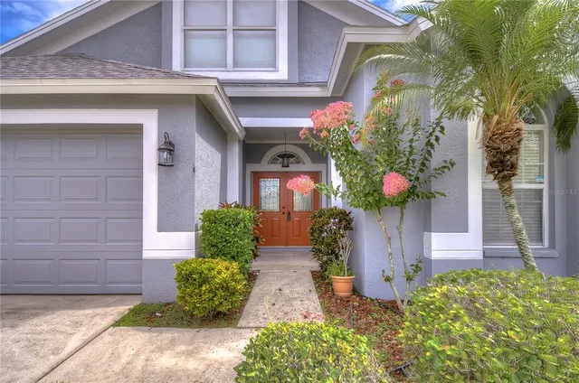a view of a hallway to an empty room with wooden floor and stairs