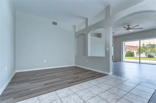 an empty room with windows and chandelier