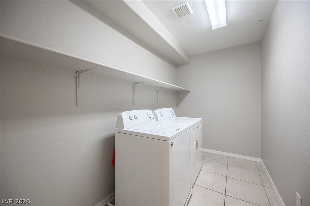 9916 Sable Point Street Las Vegas, NV 89178 - Photo 52 of 73 Functional laundry space featuring convenient shelving and durable tile flooring for everyday use.