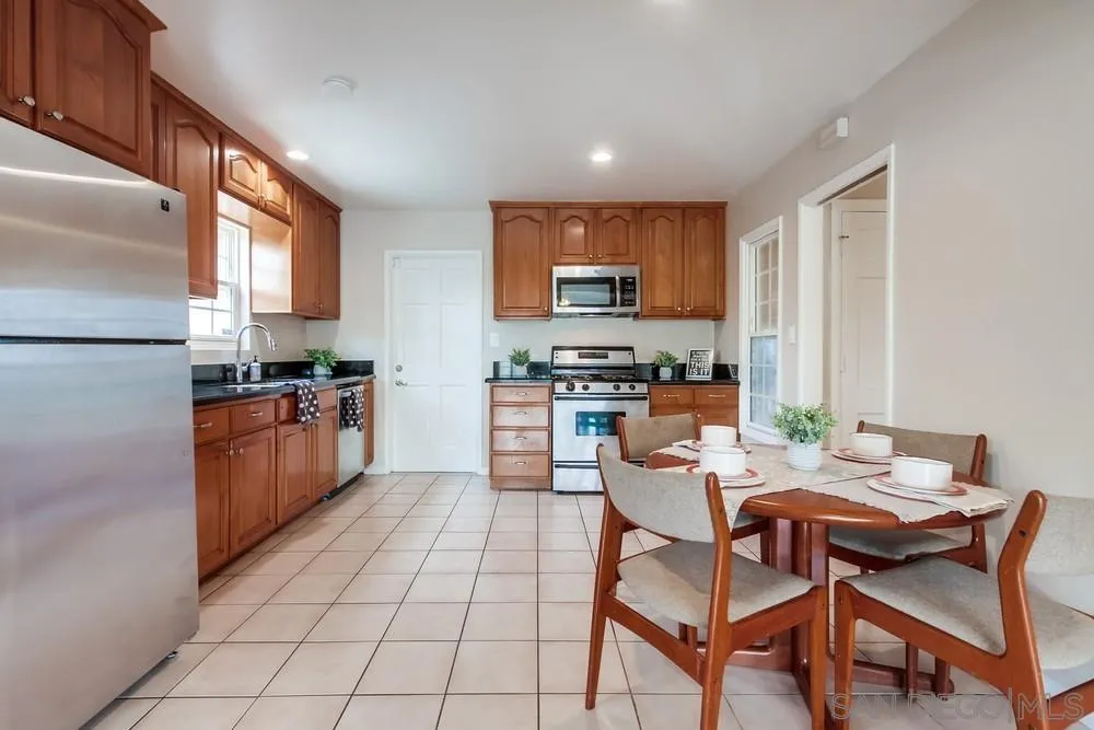 4441 Appleton Street San Diego, CA 92117 - Photo 5 of 29 a kitchen with stainless steel appliances a table and chairs in it
