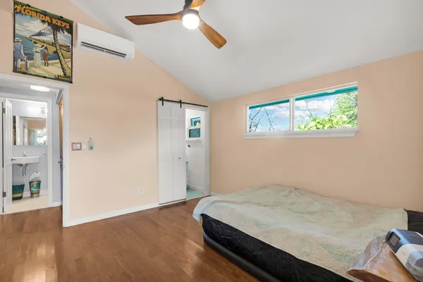 a bedroom with a bed and a painting on the wall