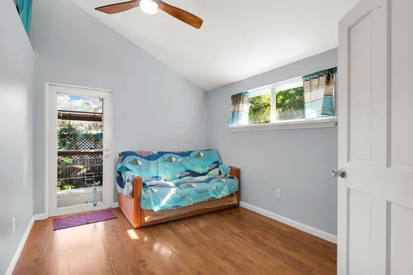a view of an empty room with window wooden floor and front door