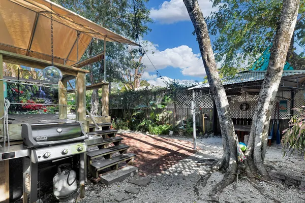a backyard of a house with barbeque oven table and chairs